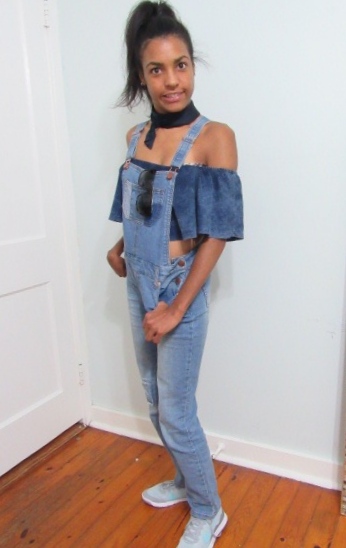 When Ghost from the Past Return- Brunette Latina looking to the side wearing jean overalls with off-the-shoulder jean top and a neck scarf with hair in a high ponytail 